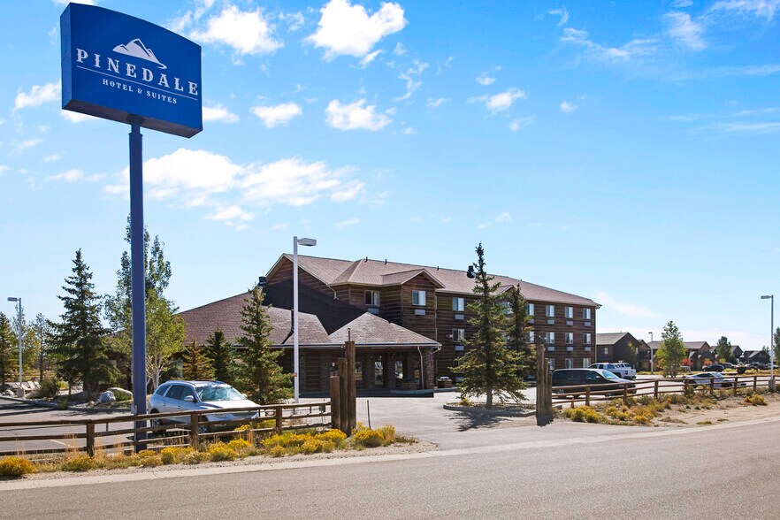 Pinedale Hotel & Suites exterior with signage and Wind River foothills